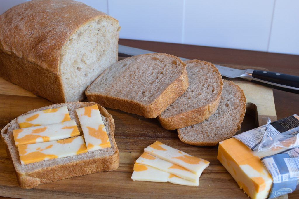 sliced bread laid out on a cutting board with some cheese